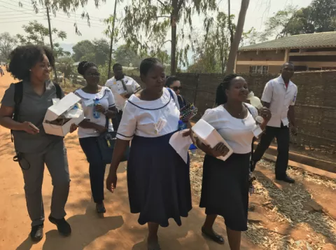 Nurses in Malawi walking through the community for outreach